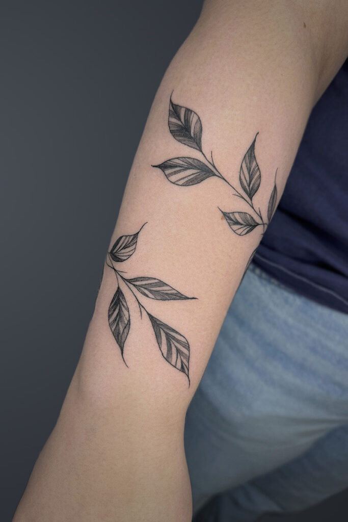 Aesthetic Tattoo Art| Fine line wrap tattoo of a vine of leaves