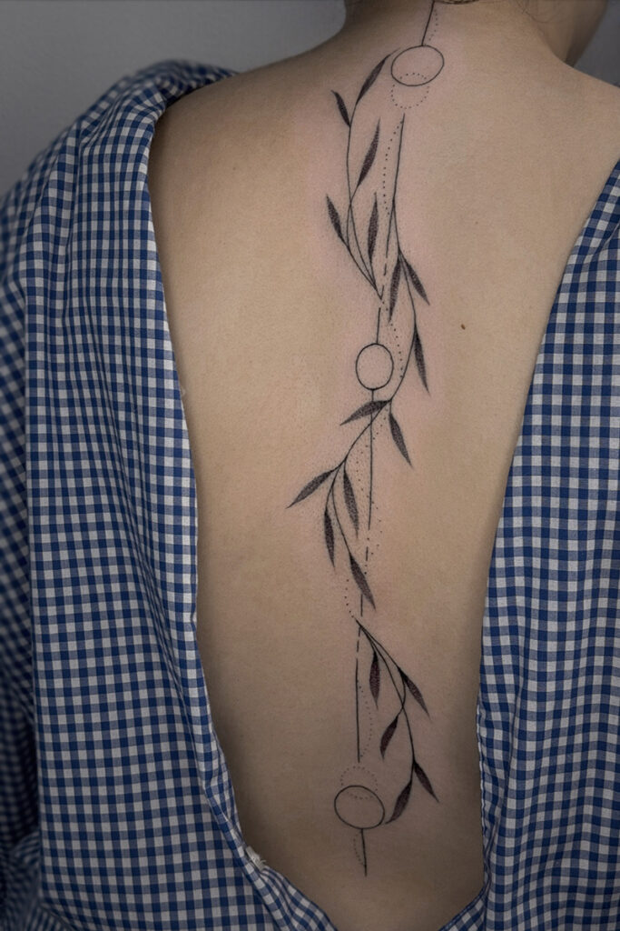 Aesthetic Tattoo Art| Fine line tattoo of vines, circles and lines going down the clients back