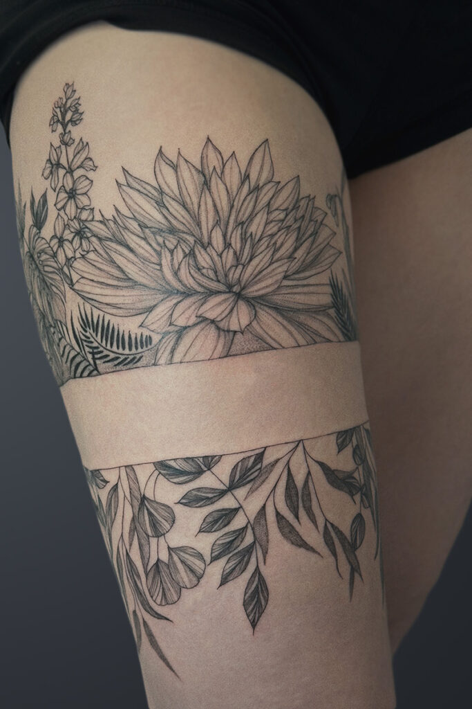 Aesthetic Tattoo Art| Fine line wrap tattoo of flowers and stems of leaves